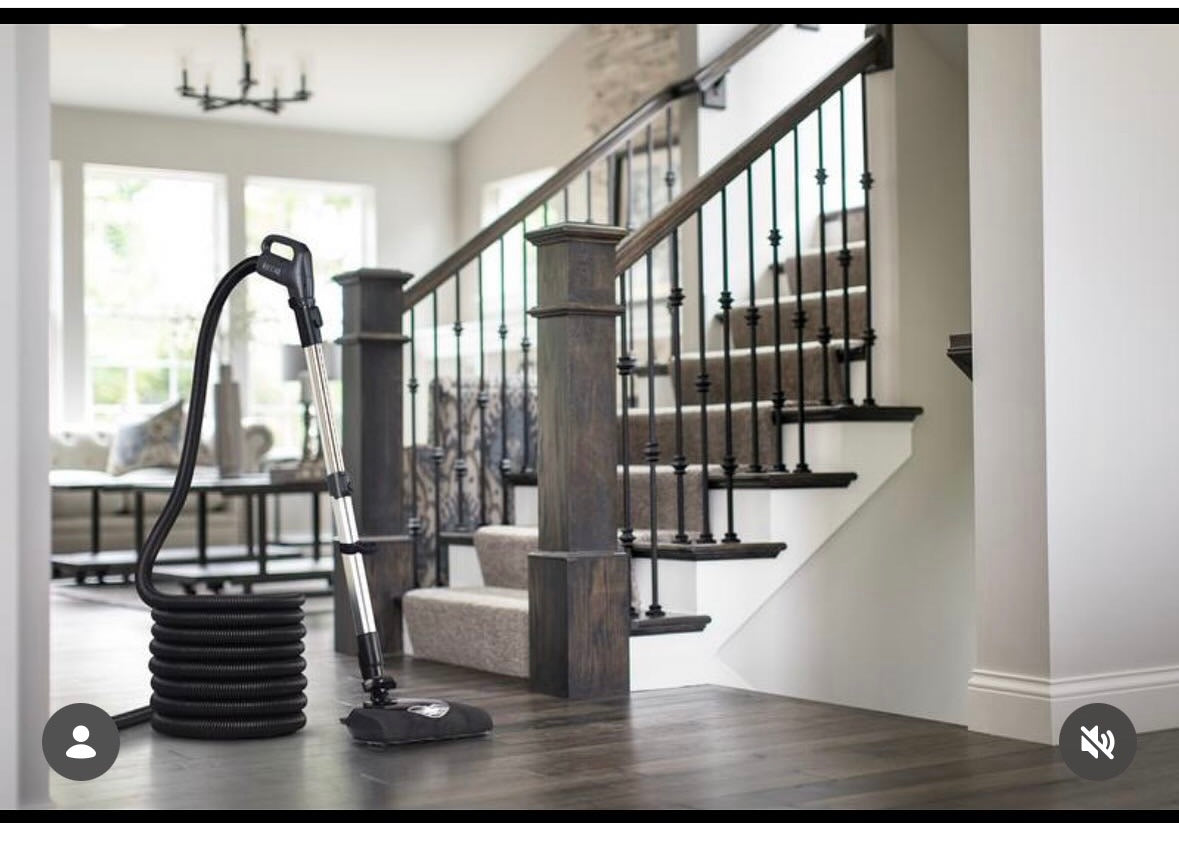 Central vacuum hose and floor attachment beside a staircase